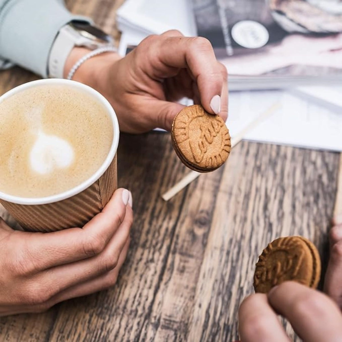 Biscoito Lotus recheado sendo servido junto a uma xícara de café.