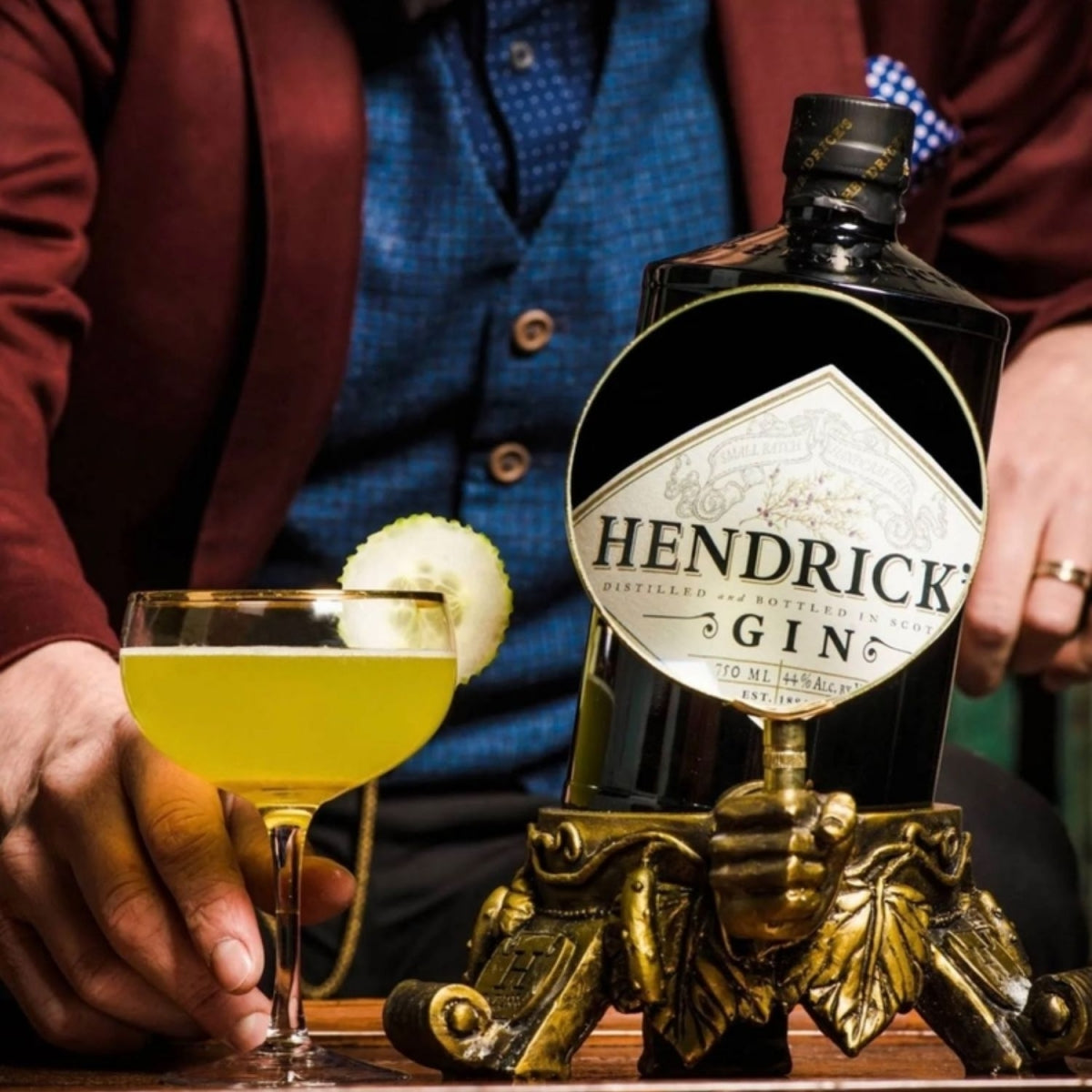 Garrafa de Gin Hendrick's ao lado de uma taça de drink com rodela de limão.