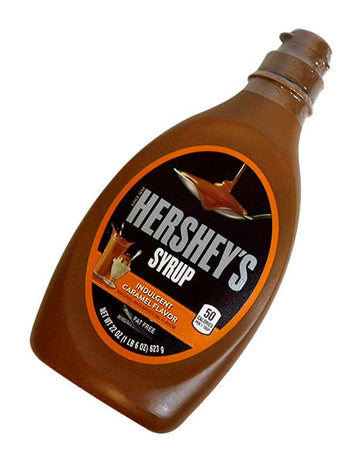 Frasco Hershey's Syrup sabor caramelo de 623 g, inclinado, com tampa squeeze.