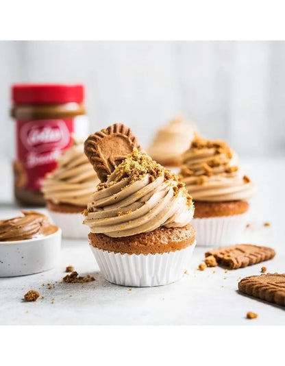 Cupcake decorado com creme, farelos e biscoito Biscoff, com o pote ao fundo.