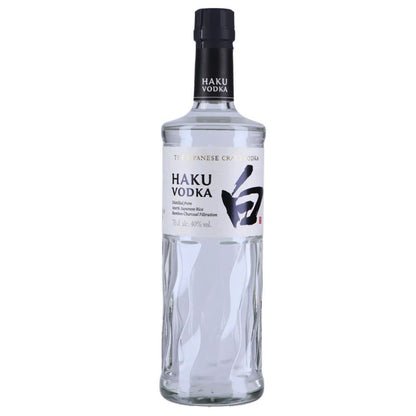 Garrafa de vidro transparente da vodka Haku com rótulo branco e tampa preta.