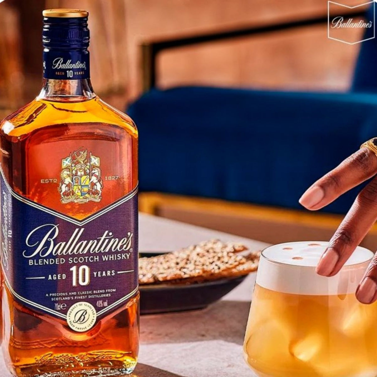 Garrafa Ballantine's 10 Anos ao lado de um copo com bebida e gelo.